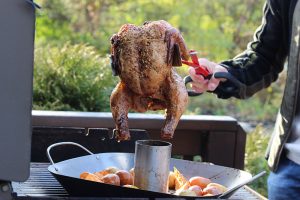 BBQ Croc tongs lift a whole chicken.