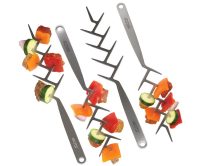 Four BBQ Croc Zig Zag Stainless Steel Skewers with food on the prongs of three of the skewers, on white background.